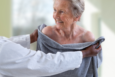 caregiver assisting senior woman on drying using a towel